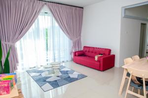 a living room with a red couch and a table at Sumayyah Homestay @ Casa Kayangan in Ipoh