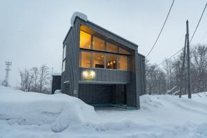 a small house in the snow on a street at Aoyama Lodge 2 in Kutchan