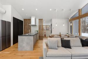 a kitchen and living room with a couch and a counter at Aoyama Lodge 2 in Kutchan