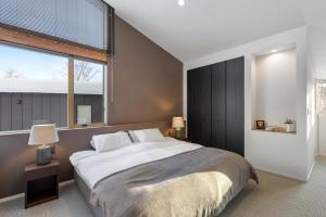 a bedroom with a large bed and a large window at Aoyama Lodge 2 in Kutchan