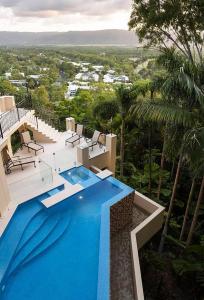 a large blue swimming pool on top of a house at Villa Aman - Tropical Luxury with Infinity Pool in Port Douglas +53 photos