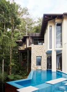 a house with a swimming pool in front of a house at Villa Aman - Tropical Luxury with Infinity Pool in Port Douglas