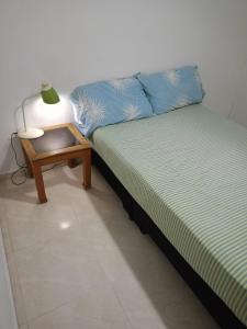 佩雷拉HABITACION CERCA AL AEROPUERTO的床上和桌子上灯