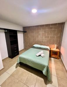 ein Schlafzimmer mit einem Bett und einer Ziegelwand in der Unterkunft Departamento Rosedal 1 in Oaxtepec