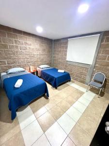 ein Schlafzimmer mit zwei Betten und einem weißen Bildschirm in der Unterkunft Departamento Rosedal 1 in Oaxtepec