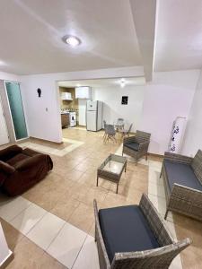 ein Wohnzimmer mit Sofa, Stühlen und einem Tisch in der Unterkunft Departamento Rosedal 1 in Oaxtepec