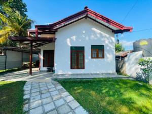 a white house with a red roof at Villa 10 Weligama in Weligama