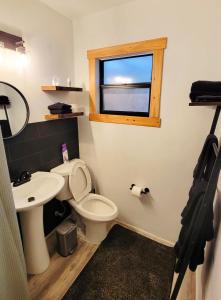 a bathroom with a toilet and a sink and a window at Beach Bungalow By The Sea 2 in Cocoa Beach