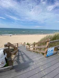 einen Holzsteg zum Strand mit dem Meer in der Unterkunft Lake Michigan Beach House in Shelby