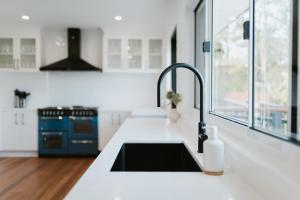 a white kitchen with a sink and a stove at Monty's House in Montville