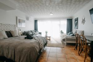 a bedroom with a bed and a living room at Ohana - Stylish Central Byron Studio - free secure parking in Byron Bay