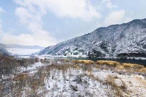 a house in the middle of a snow covered mountain at Soyang Dam Pension in Chuncheon