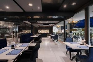 a restaurant with tables and chairs and a bar at Skye Hotel Bangkok in Bangkok