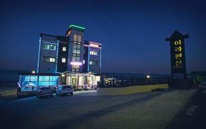 a building with cars parked in a parking lot at night at Pohang Ara Ocean View Pension in Pohang