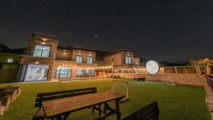 a wooden bench in front of a building at night at Pause Kids Pool Viila A in Yeosu