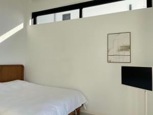 a white room with a bed and some windows at Wando Space in House in Wando