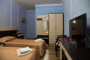 a hotel room with two beds and a flat screen tv at Mini Otel Teremki in Salekhard