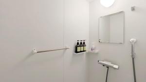 a bathroom with a shower with bottles of wine at 与那国島ホテル むんぶステイ ナンタ浜 in Yonaguni