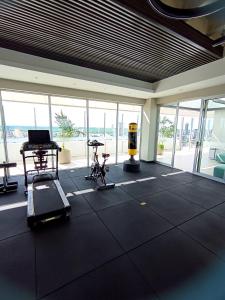 a gym with a treadmill and exercise equipment in a room with windows at Dpto Hestia en Equipetrol in Santa Cruz de la Sierra