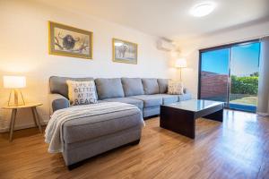 a living room with a couch and a table at Blue Seas Holiday Villas in Scamander