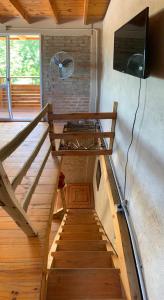 圣罗莎卡拉穆奇塔县Bauha Mini Apart的一个房间里有楼梯、一台电视和一台电视机