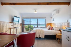 a bedroom with a bed and a large window at Blue Seas Holiday Villas in Scamander