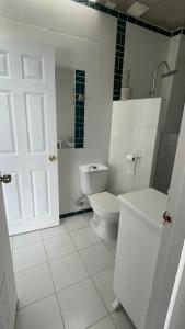 a white bathroom with a toilet and a sink at My little Santorini in Guanaqueros +9 photos