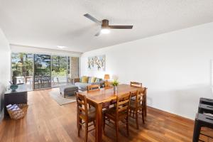 a living room with a table and a ceiling fan at Beachfront Retreat at Burleigh, Breezy and Cosy in Gold Coast