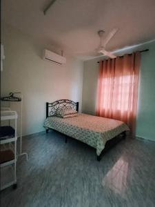 a bedroom with a bed in a room with a window at D'Batu Hampar Homestay Chalok in Kampong Batu Hampar