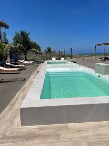 a swimming pool with the ocean in the background at Boca de agua Villas in Nautla +7 photos