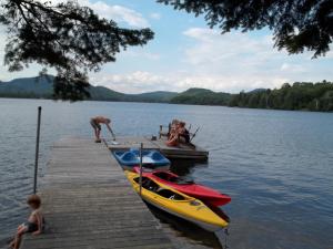 un groupe de personnes sur un quai avec des bateaux sur un lac dans l'établissement Chalets et Studios Le Vent Du Nord, à Lac-Supérieur