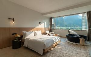 een hotelkamer met een bed en een bad bij Yangshuo One Thousand and One Courtyard Views B&B in Yangshuo +37 foto's