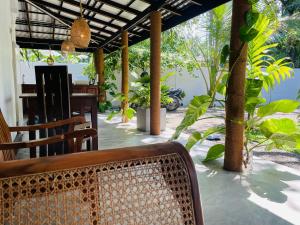 a patio with chairs and a table and trees at Bael House Ahangama in Ahangama