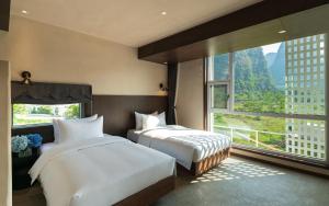阳朔Yangshuo One Thousand and One Courtyard Views B&B的一间有大窗户的房间里有两张床