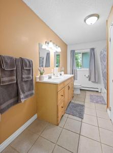 a bathroom with a sink and a toilet and a tub at Midnight Sun Viewpoint Aurora in Fairbanks +29 photos
