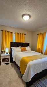 a bedroom with a bed with yellow curtains at Midnight Sun Viewpoint Aurora in Fairbanks