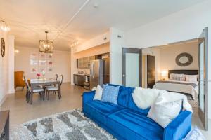 a living room with a blue couch and a bedroom at 5M412- Sophisticated 1BR Condo in Nashville