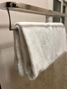 a white towel hanging on a towel rack in a bathroom at أجنحة المدينة للشقق المفروشة in Al Madinah