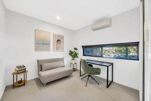 soggiorno con sedia e scrivania di Stylish Three-Story Getaway with Balcony - Clayton a Clayton North