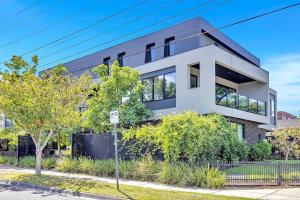 una grande casa bianca con alberi e cespugli di Stylish Three-Story Getaway with Balcony - Clayton a Clayton North