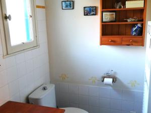 a bathroom with a toilet and a sink and a window at Spacieuse maison familiale à Groix avec jardin - FR-1-813-21 in Groix