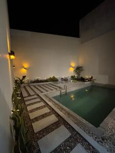 a swimming pool in a building at night at Namuya Alam Villa Private Pool, Rooftop , BBQ & Karaoke in Bandung