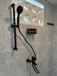 a shower with a blow dryer in a bathroom at Namuya Alam Villa Private Pool, Rooftop , BBQ & Karaoke in Bandung