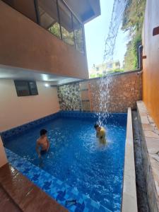 a man and a dog in a swimming pool at Khách sạn Galaxy in Tam Ðảo