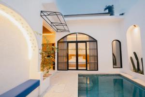 a home with a swimming pool and a house at Graha Madeline in Ketewel