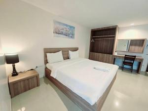 a bedroom with a large white bed in a room at Similan Mansion in Bangsaen