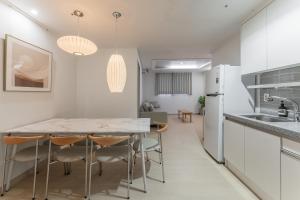 a kitchen and dining room with a table and chairs at Marant Residence Hotel Busan Station in Busan