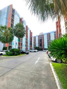 ein Parkplatz mit vor einem Gebäude geparkten Autos in der Unterkunft Similan Mansion in Bangsaen