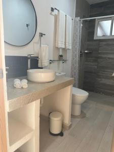 a bathroom with a sink and a toilet and a mirror at Boca de agua Villas in Nautla