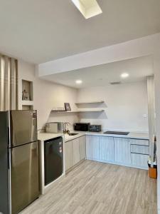 a kitchen with stainless steel appliances and blue cabinets at Queensland Suites at Aru Suites, Kota Kinabalu 2 Bedroom Family Suite in Kota Kinabalu